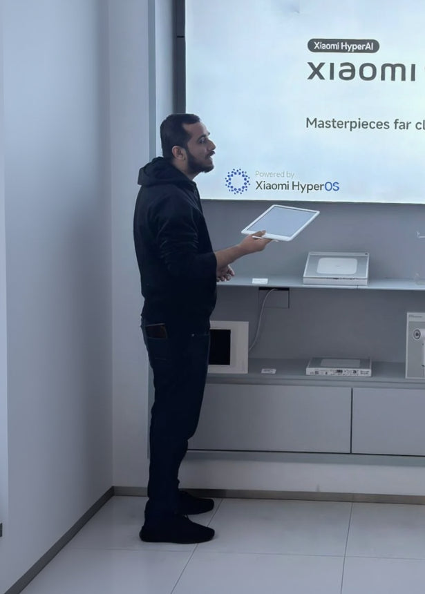 Person interacting with a large screen displaying Xiaomi 15T Series in a store setting.