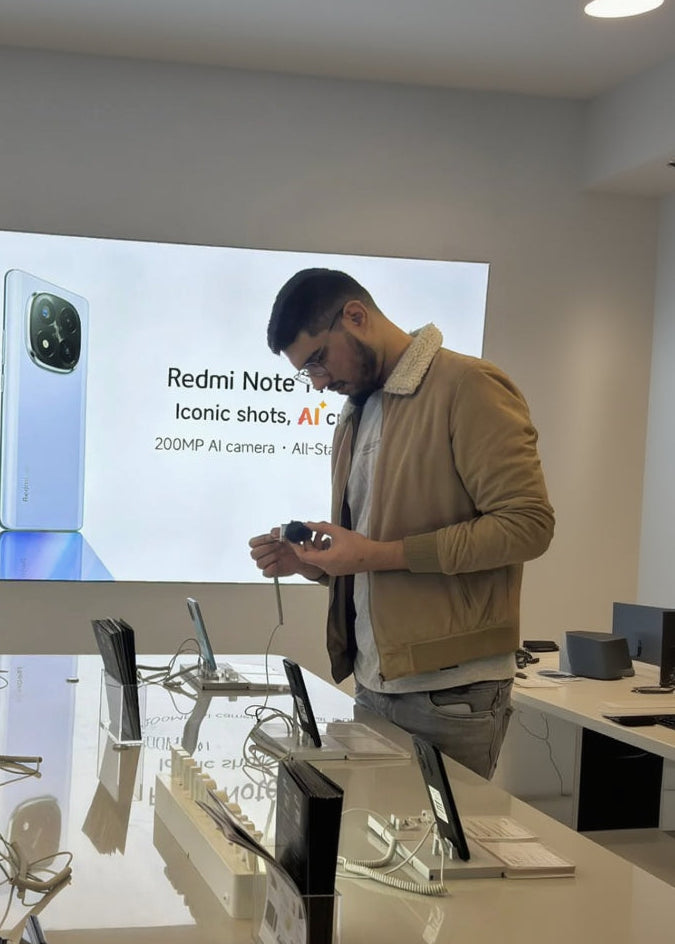 Man using a camera in front of a screen displaying Redmi Note 10 Pro.