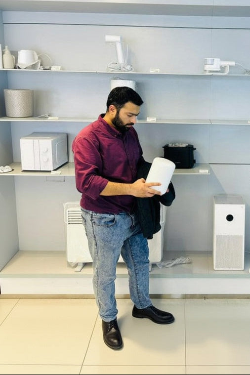 Man in a smart home store examining electronic devices.
